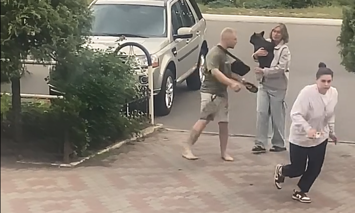 у Кременчуці біля кафе чоловік розмахує повідцем, його сестра тримає собаку, а працівниця кафе тікає